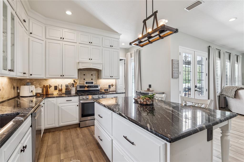 345 Cypress Isles Road Osteen, FL 32764 - Photo 11 of 41 a kitchen with stainless steel appliances granite countertop a sink a stove and cabinets