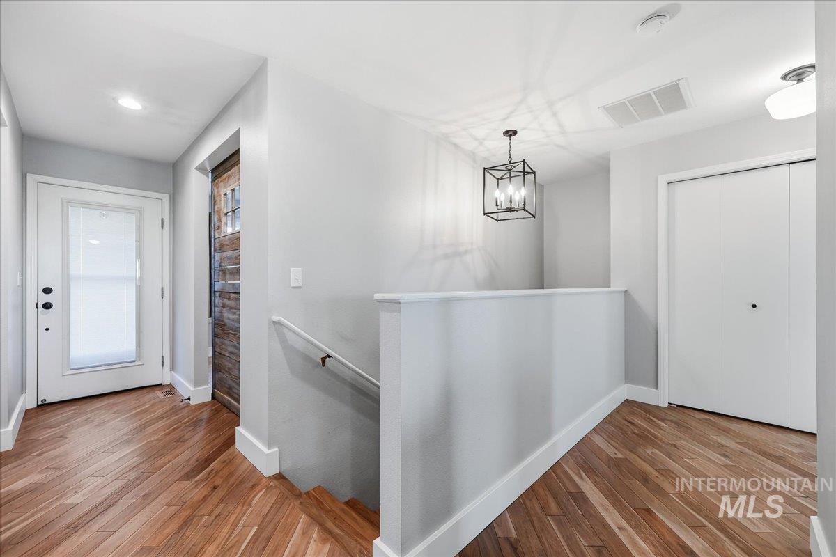 3293 West Twin View Lane Meridian, ID 83642 - Photo 7 of 43 Corridor featuring an upstairs landing, wood finished floors, a chandelier, and recessed lighting