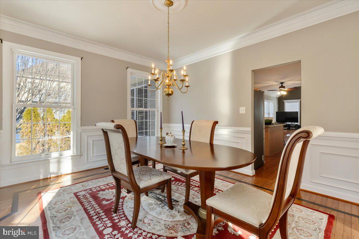 13714 Monet Court Chantilly, VA 20151 - Photo 16 of 58 a dining room with furniture a chandelier and wooden floor