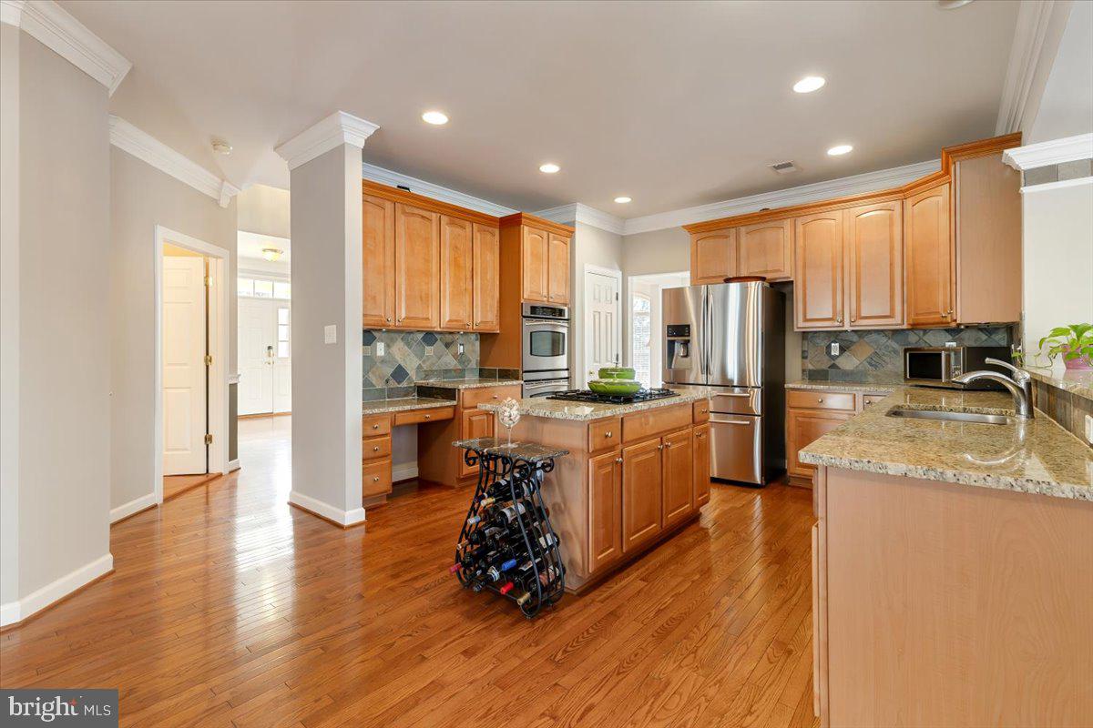13714 Monet Court Chantilly, VA 20151 - Photo 19 of 58 a large kitchen with stainless steel appliances granite countertop a stove a sink a refrigerator and white cabinets with wooden floor