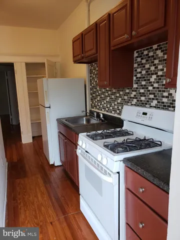 a kitchen with granite countertop a stove and a refrigerator