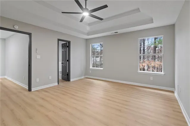 a view of an empty room with window and wooden floor