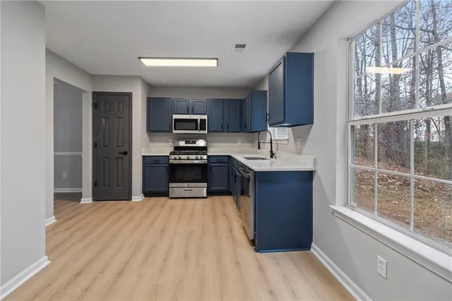 a kitchen with stainless steel appliances granite countertop a refrigerator stove and sink