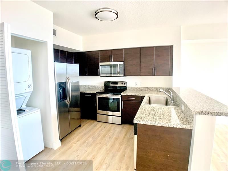a kitchen with stainless steel appliances kitchen island a refrigerator sink and stove