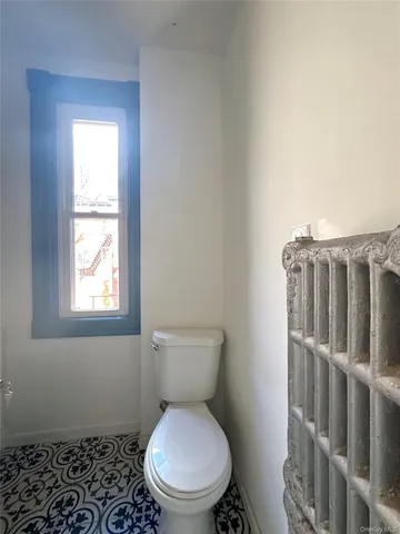 a white toilet sitting next to a window