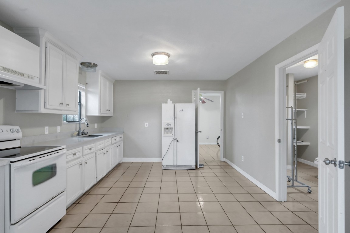7644 Spring Cypress Road Spring, TX 77379 - Photo 13 of 28 a kitchen with white cabinets and white appliances
