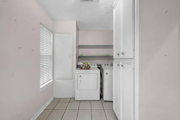 a large white kitchen with a sink and cabinets