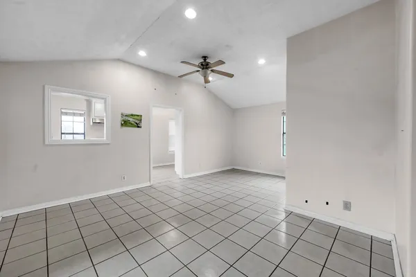 an empty room with windows and fan