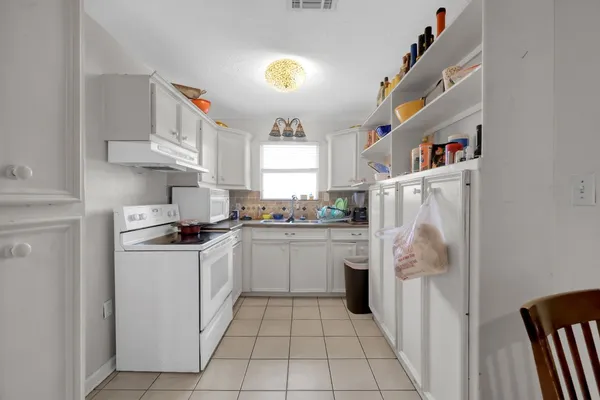 an empty room with windows and ceiling fan