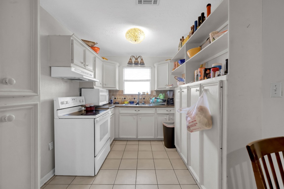 7644 Spring Cypress Road Spring, TX 77379 - Photo 25 of 28 a kitchen with a refrigerator and a stove