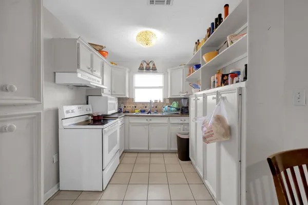an empty room with windows and ceiling fan