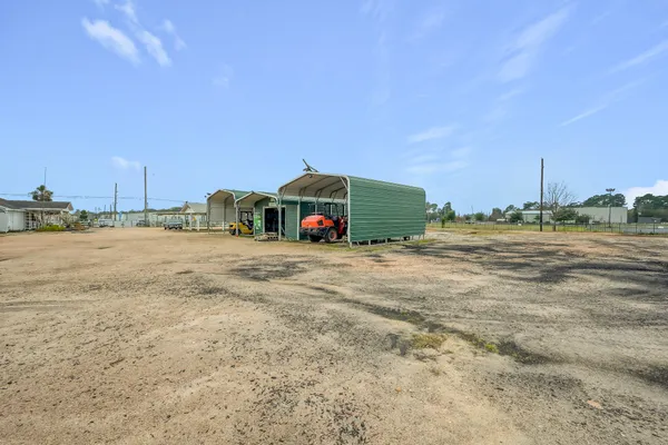 a view of a house with a yard and large tree