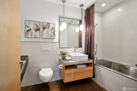 a bathroom with a tub sink and mirror