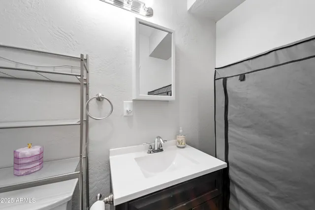 a view of a hallway with wooden floor and a bathroom