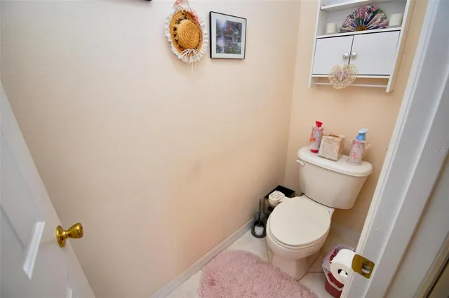 a white toilet sitting next to a white sink and vanity