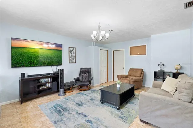 a living room with furniture and a chandelier