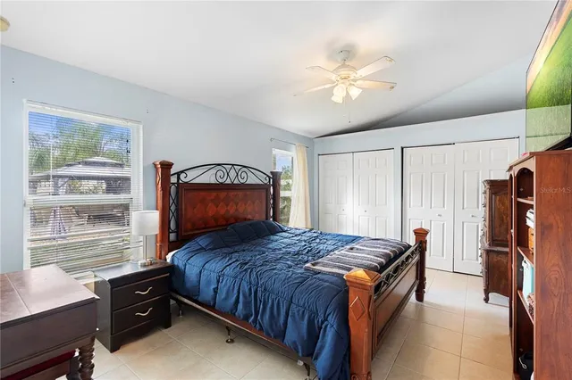 a bedroom with a bed a flat screen tv and a book shelf