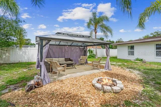 a backyard of a house with barbeque oven table and chairs