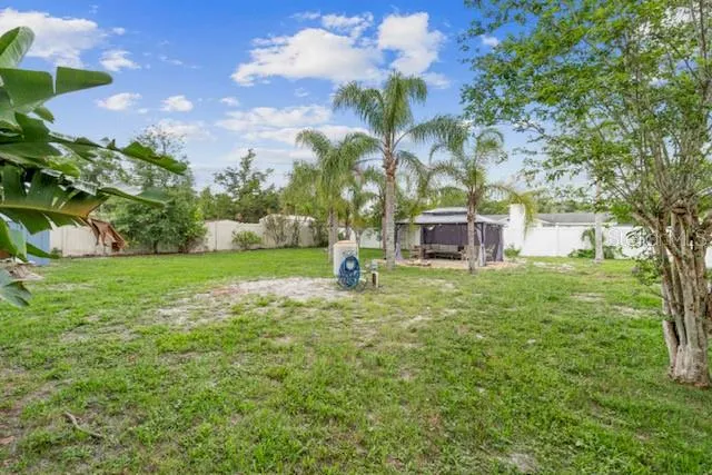 a view of a chair and table in backyard of the house