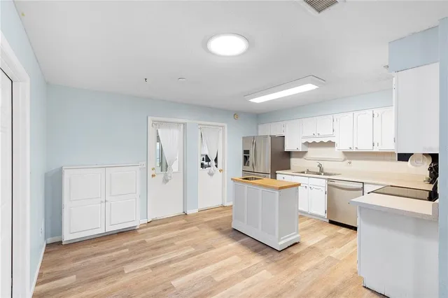 a kitchen with stainless steel appliances a refrigerator and a stove top oven