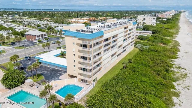 a front view of a multi story residential apartment building with yard and bench