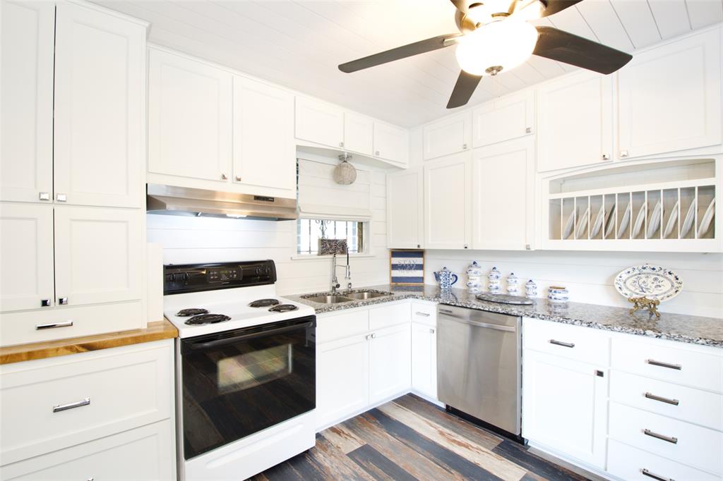 1307 North 65th Street Waco, TX 76710 - Photo 10 of 35 a kitchen with granite countertop a stove sink and cabinets