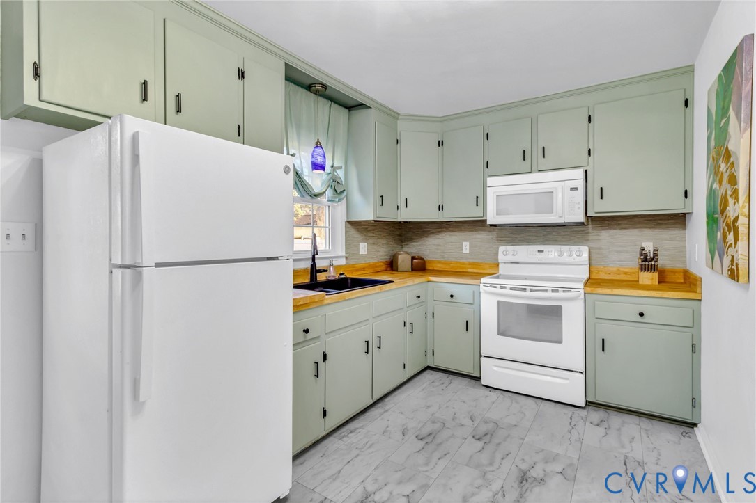 151 Badger Road Deltaville, VA 23043 - Photo 11 of 43 a kitchen with cabinets appliances a sink and a refrigerator