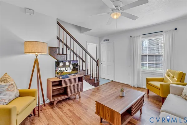 a living room with furniture and a wooden floor