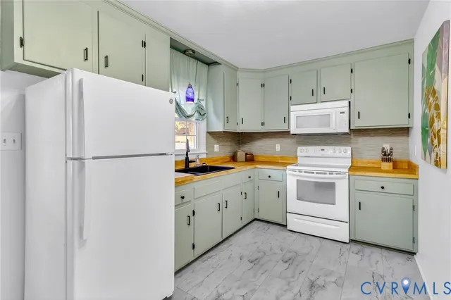a kitchen with cabinets appliances a sink and a refrigerator