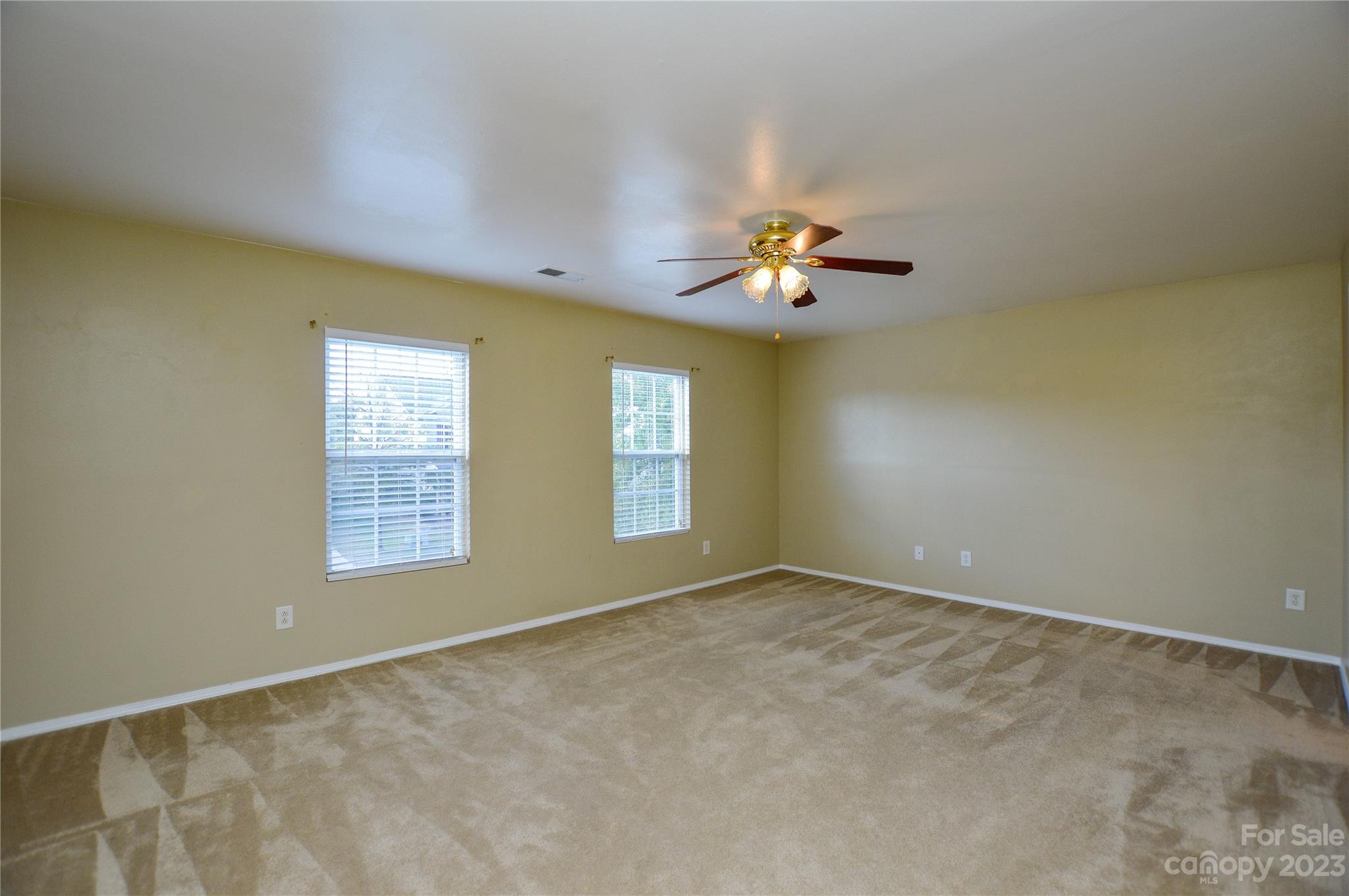 9310 John Russell Road Charlotte, NC 28215 - Photo 29 of 40 an empty room with windows and chandelier fan