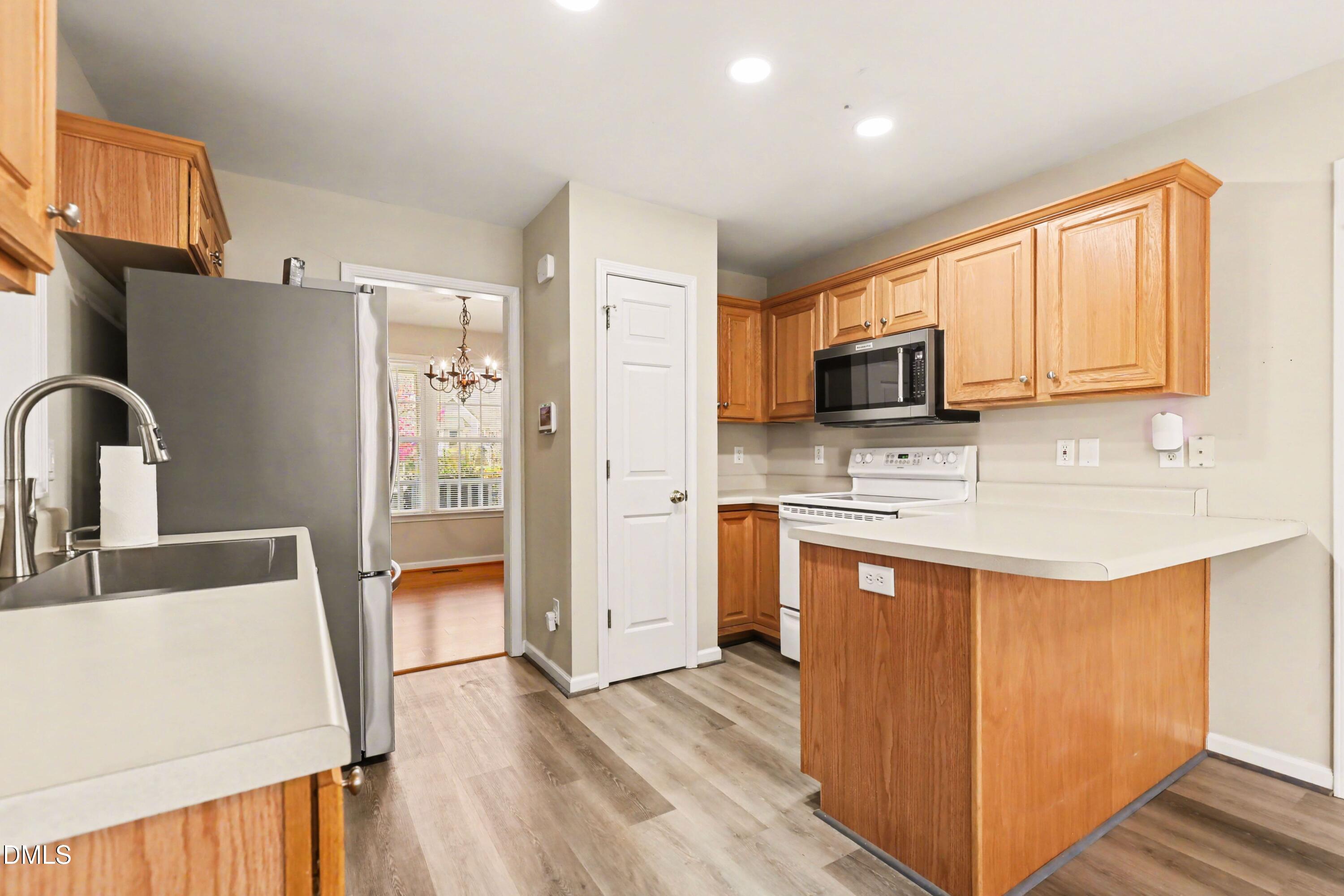 390 Eagle Stone Ridge Youngsville, NC 27596 - Photo 11 of 29 a kitchen with stainless steel appliances a sink a stove a refrigerator cabinets and a dining table