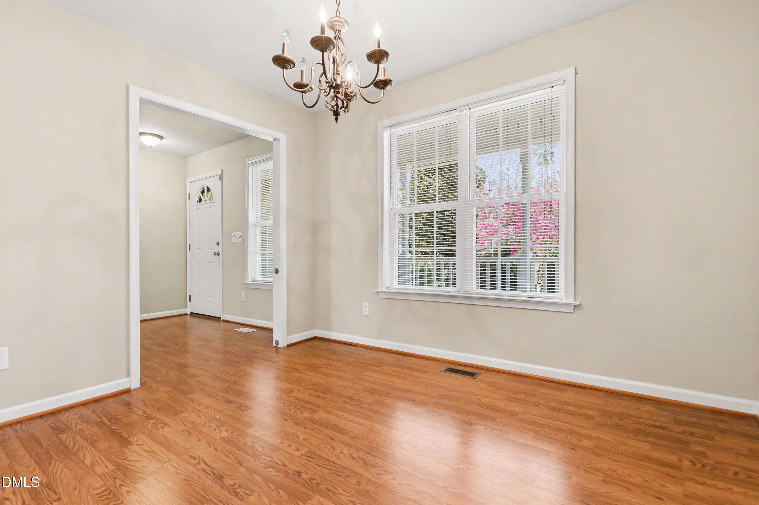 390 Eagle Stone Ridge Youngsville, NC 27596 - Photo 13 of 29 an empty room with wooden floor chandelier and windows
