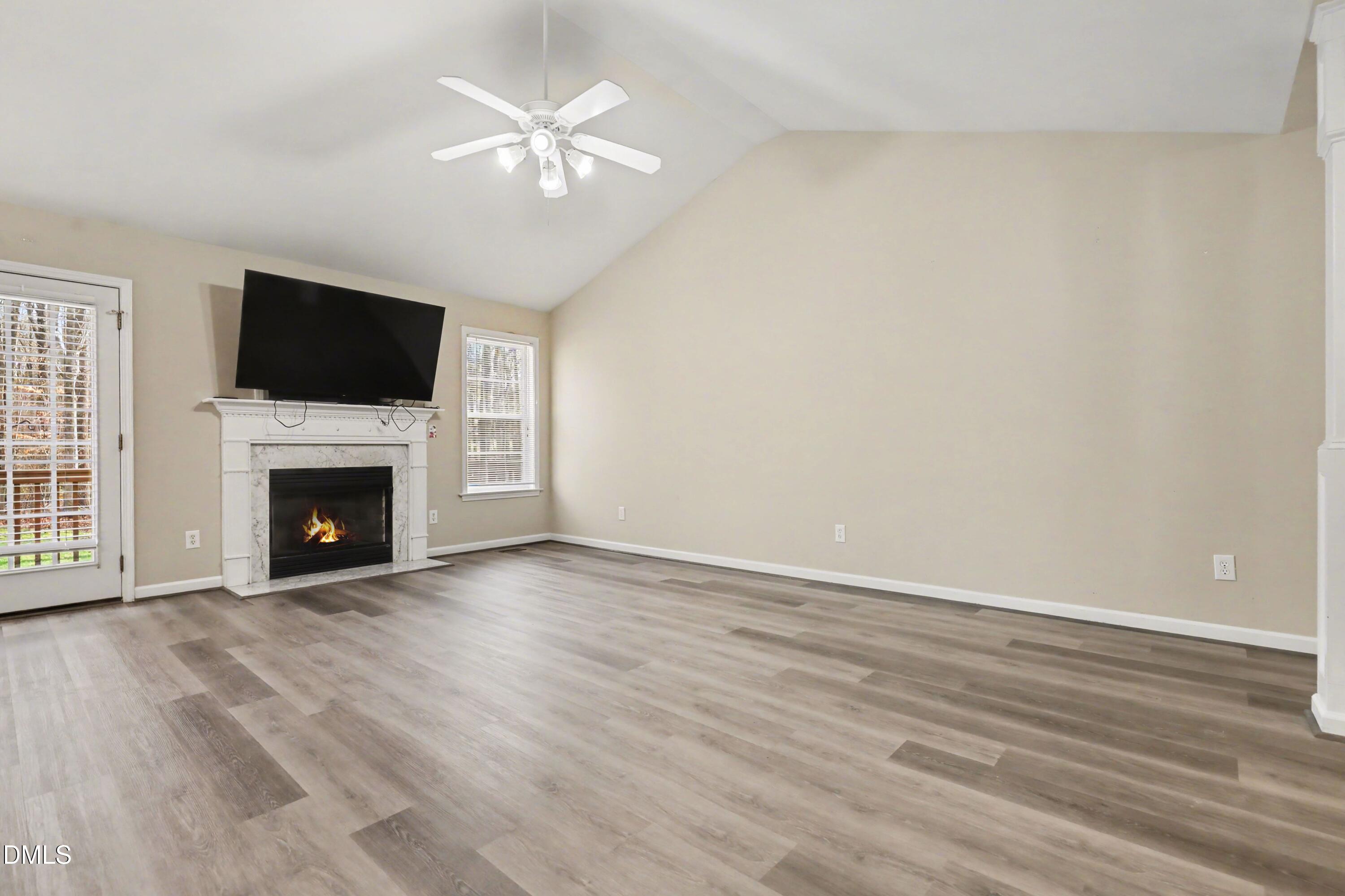390 Eagle Stone Ridge Youngsville, NC 27596 - Photo 6 of 29 a view of a livingroom with a fireplace a ceiling fan and wooden floor