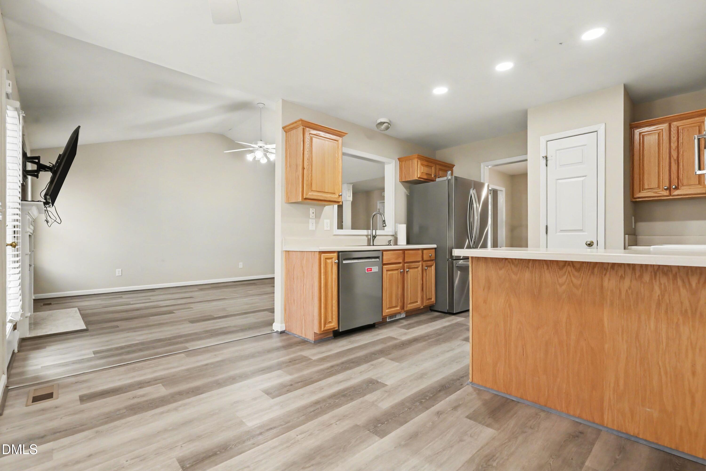 390 Eagle Stone Ridge Youngsville, NC 27596 - Photo 8 of 29 a kitchen with stainless steel appliances wooden floors and white walls