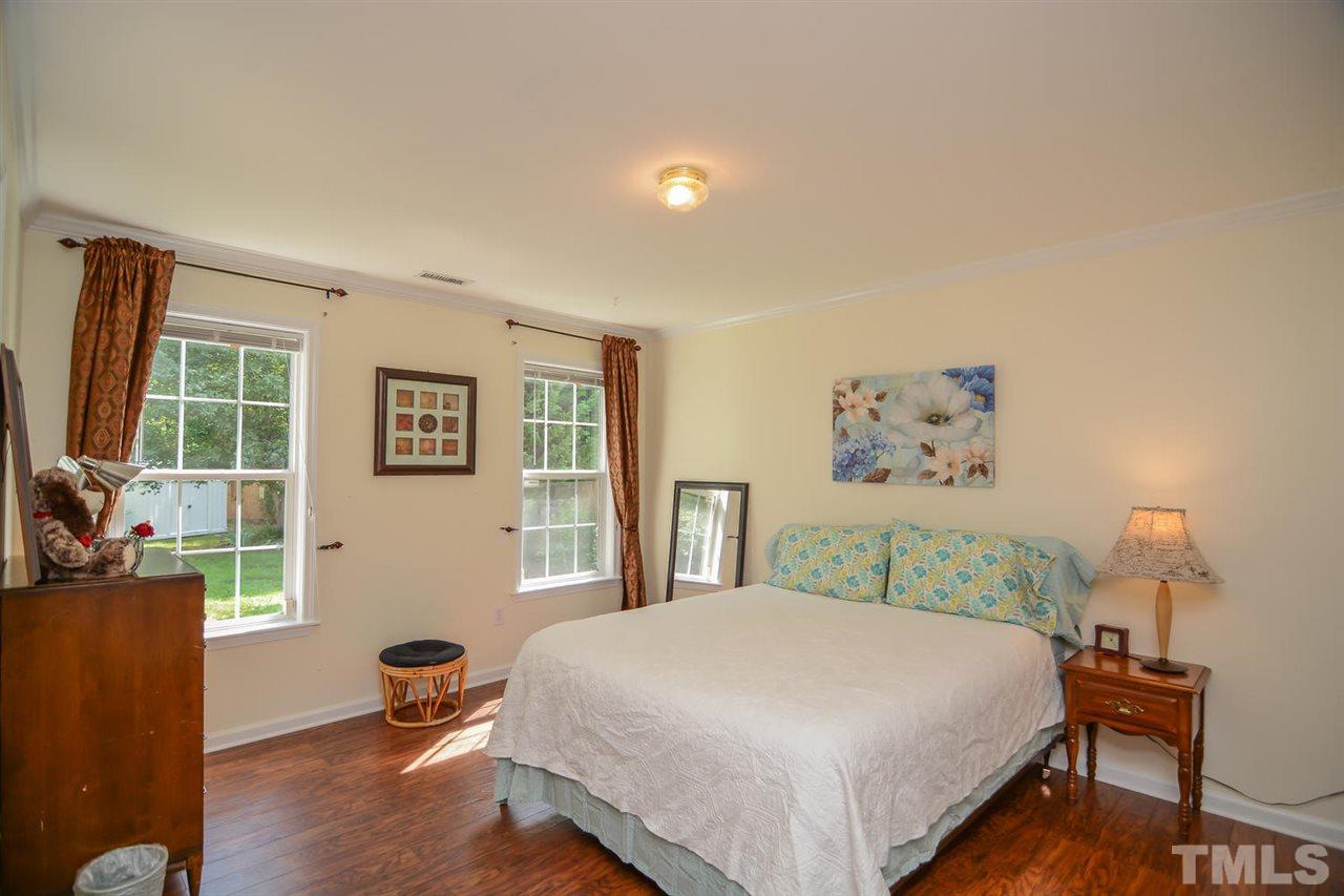 4412 Archibald Way Raleigh, NC 27616 - Photo 17 of 25 a bedroom with a bed and wooden floor