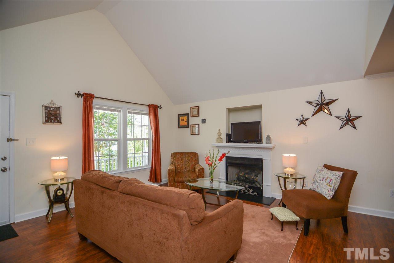 4412 Archibald Way Raleigh, NC 27616 - Photo 4 of 25 a living room with furniture a flat screen tv and a fireplace