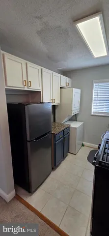 a kitchen with stainless steel appliances granite countertop a refrigerator and a stove