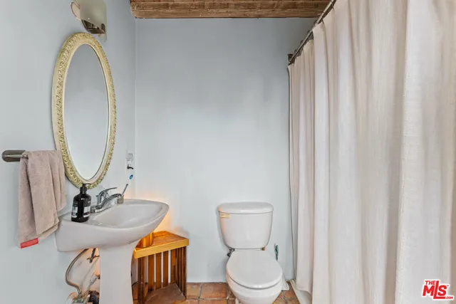 a bathroom with a toilet a sink and a mirror
