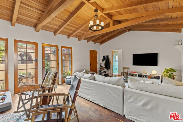 a living room with furniture a flat screen tv and a floor to ceiling window