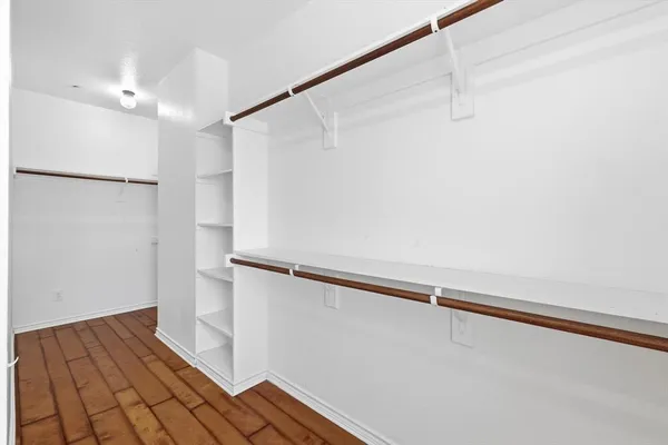 a view of walk in closet with empty racks