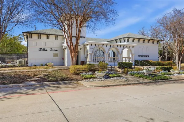 a front view of a building with large trees