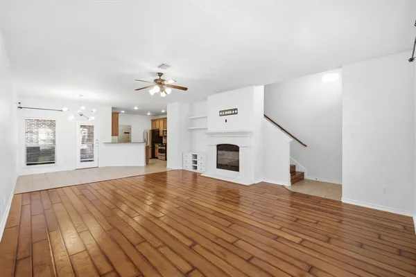 a view of a livingroom with wooden floor and a ceiling fan