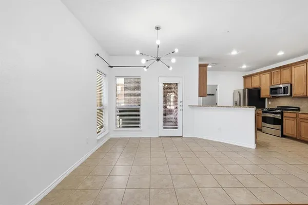 a large white kitchen with granite countertop a stove top oven a sink dishwasher and a refrigerator with wooden floor