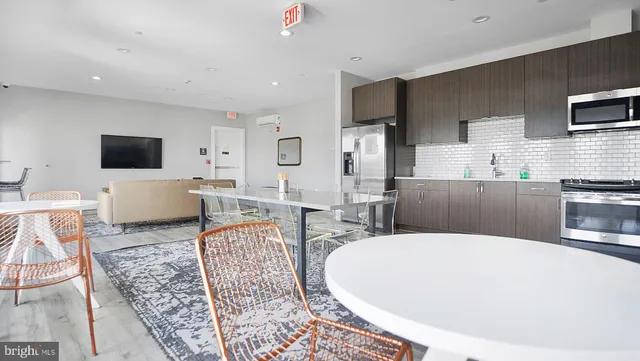 a living room with furniture a flat screen tv and kitchen view