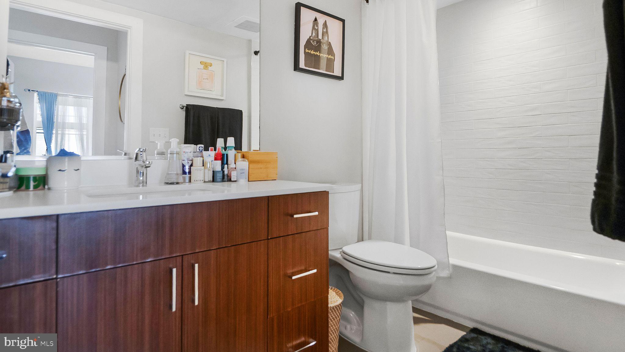 1111 Orren Street Northeast, Unit 407 Washington, DC 20002 - Photo 7 of 19 a bathroom with a sink a toilet and shower