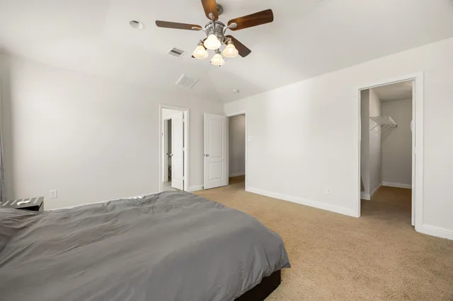 a bed room with a bed and a ceiling fan