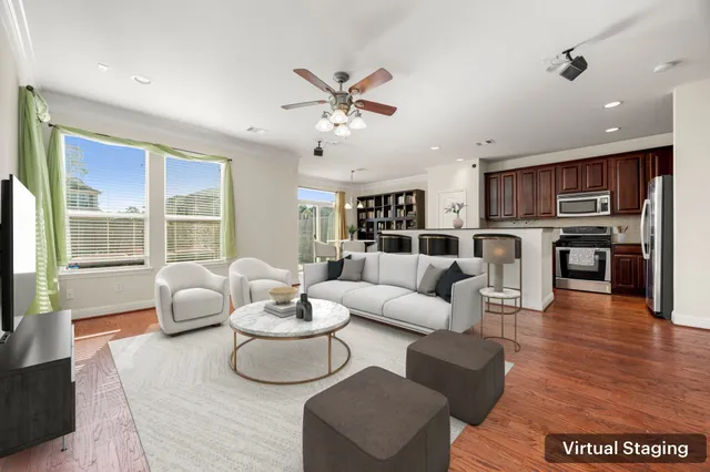 a living room with furniture kitchen and a wooden floor