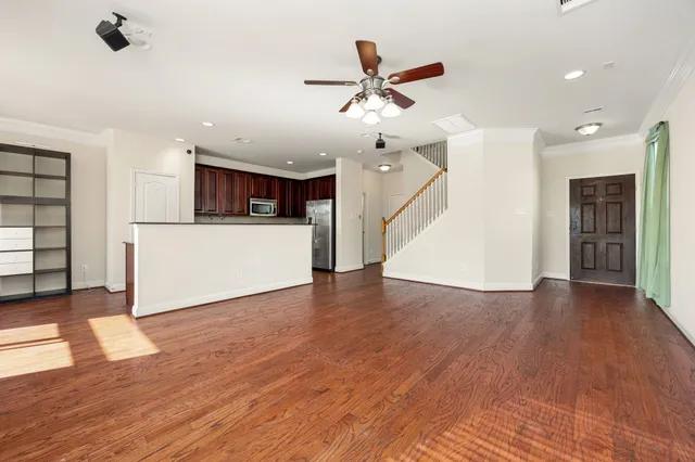 a view of a living room with wooden floor and ceiling fan