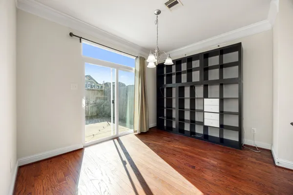 a view of a room with a large window and wooden floor