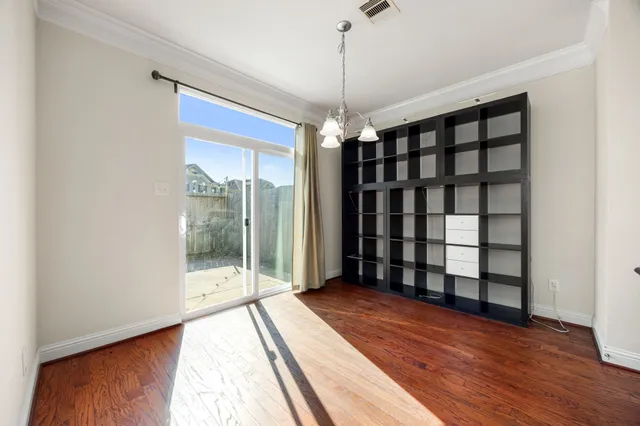 a view of a room with a large window and wooden floor